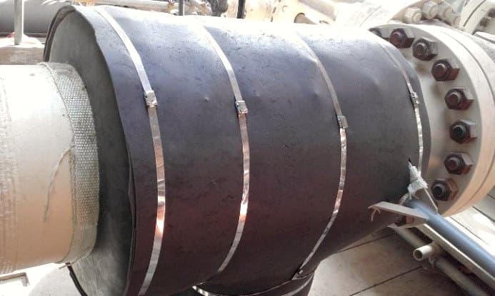 Large flanged pipe section insulated and secured with steel bands