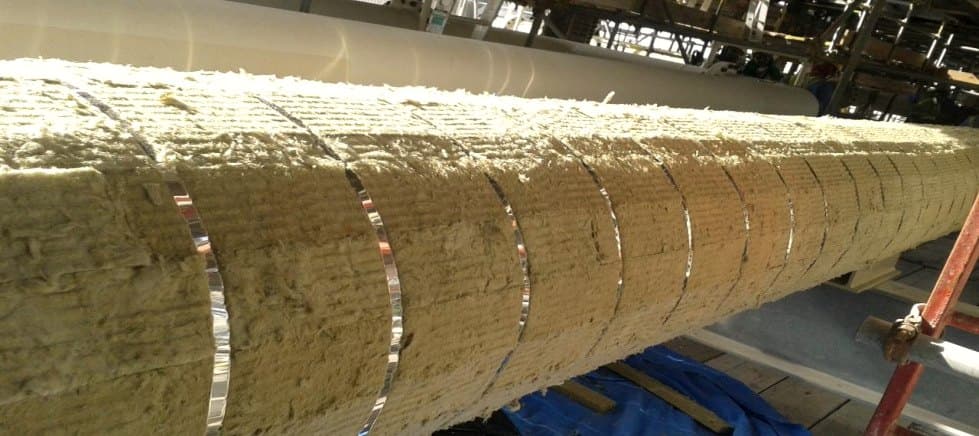 Mineral wool insulation sections fitted along a horizontal pipe run