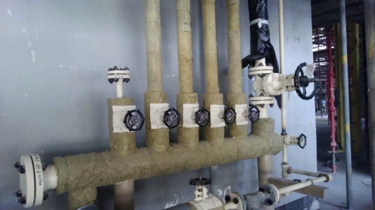 Insulated pipe manifold with valves on an industrial process skid