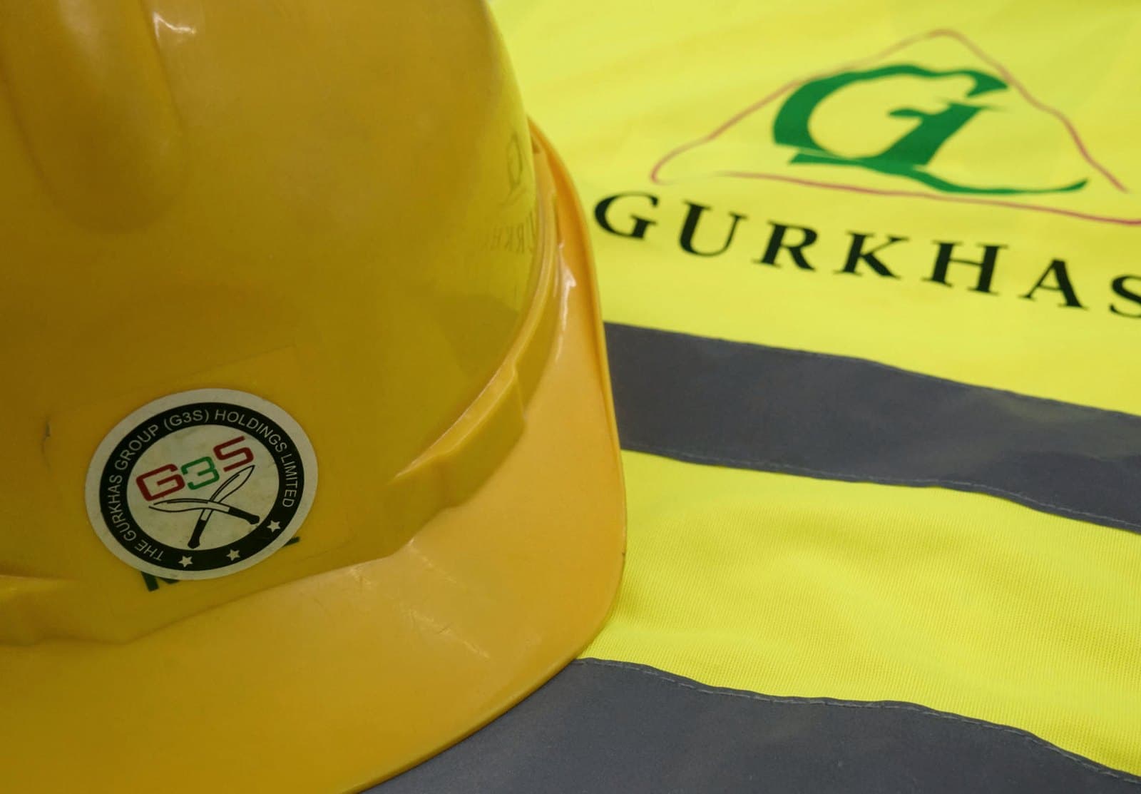 Gurkhas-branded safety helmet resting on a high-visibility jacket