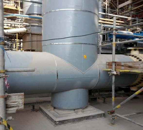 Vertical process vessel insulated and finished with metal cladding