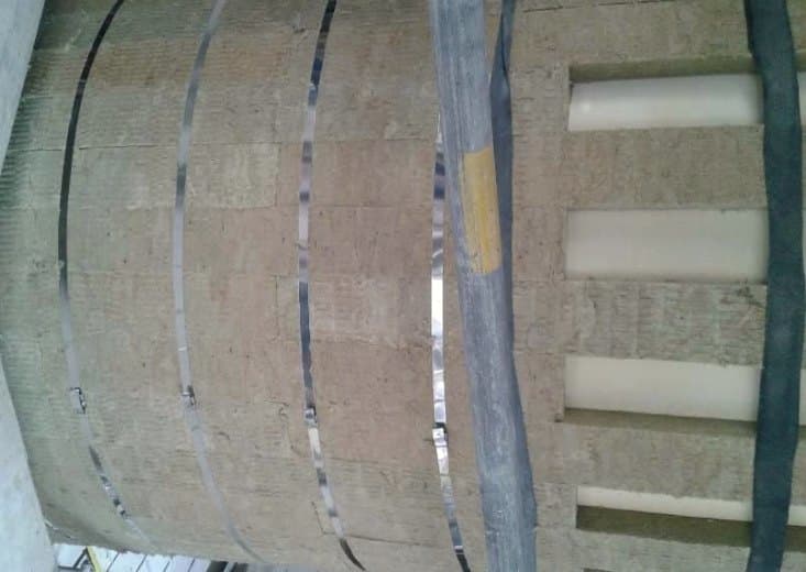 Banding straps securing insulation around the curved wall of a vessel